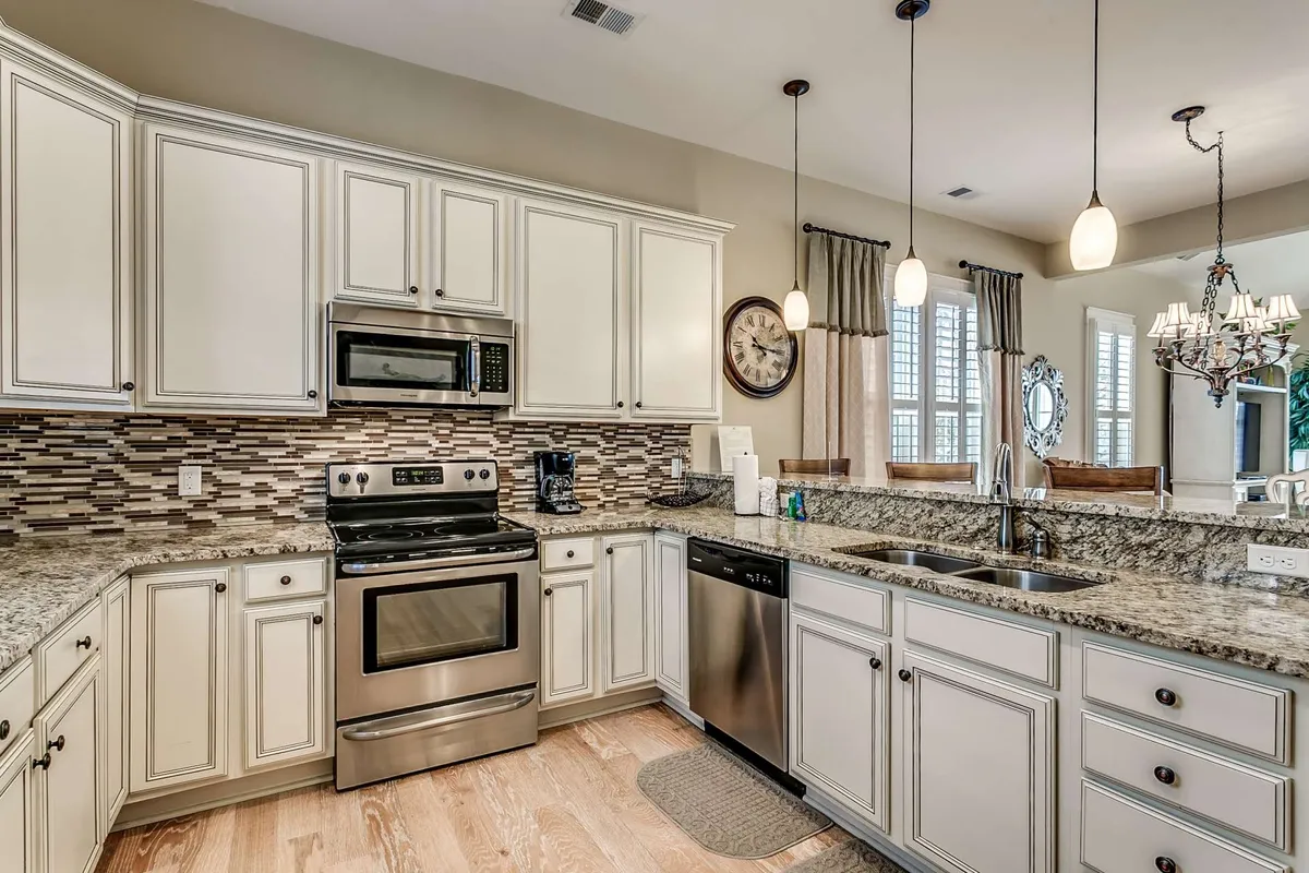 A modern kitchen featuring sleek granite countertops, stainless steel appliances, elegant backsplash tiles, and contemporary lighting. The space is both functional and inviting, ideal for cooking feasts, baking with family, or enjoying morning coffee together.